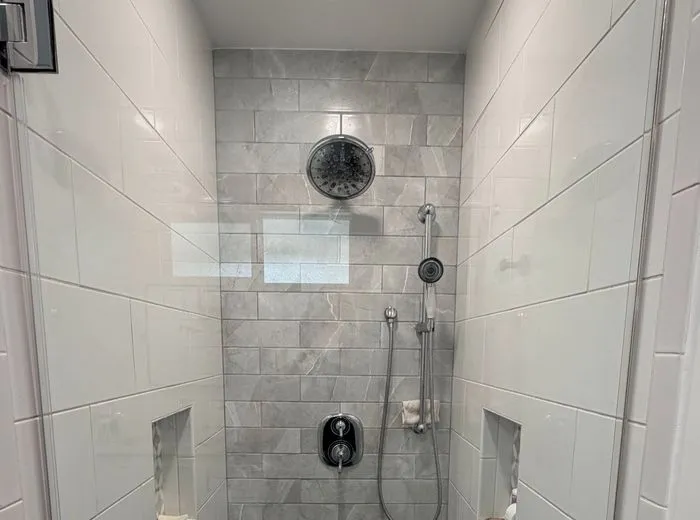 Clean walk-in shower with white tile after a deep cleaning