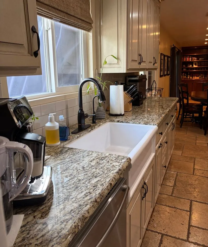 Kitchen counter and farmhouse sink in warm window light