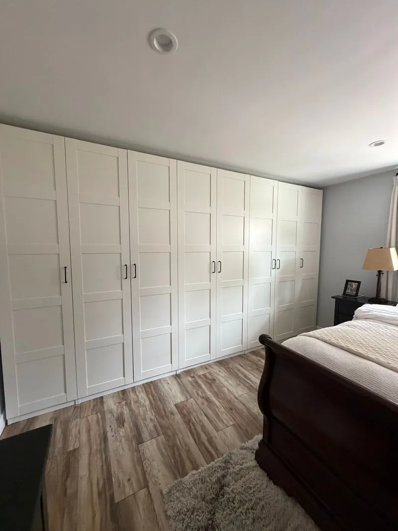 Clean bedroom with a wall of white wardrobe doors